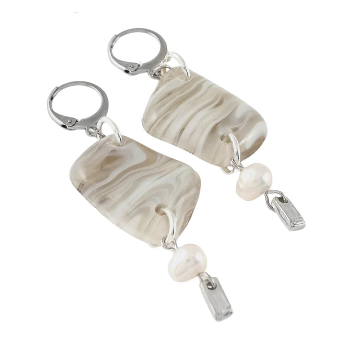 Boucles d'oreilles suspendues avec pierre blanche et perle au bout par ANne-Marie Chagnon vues de près