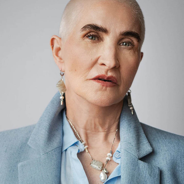 Femme portant des Boucles d'oreilles suspendues avec pierre blanche et perle au bout par ANne-Marie Chagnon