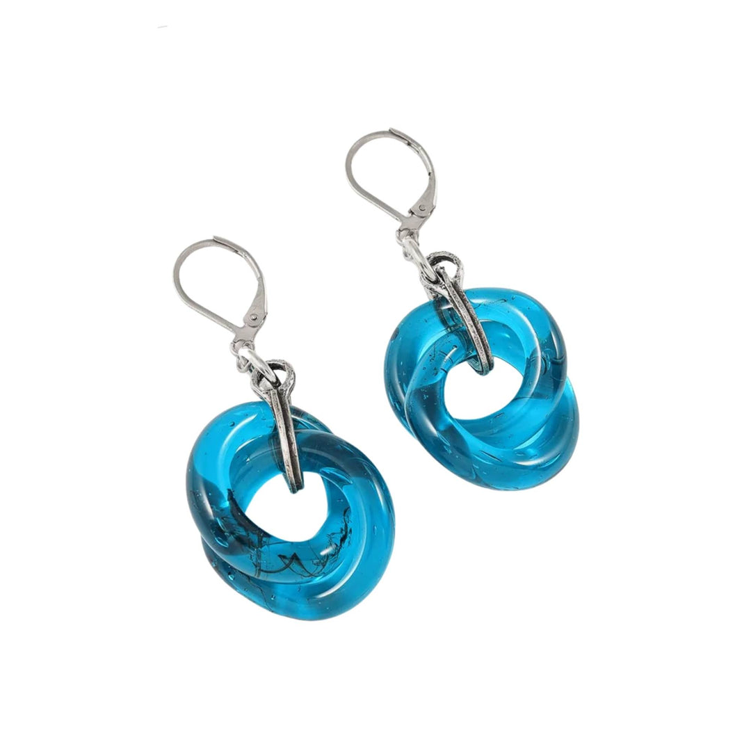 Boucles d'oreilles bleues en verre entrelacés par Anne-Marie Chagnon déposées sur une surface