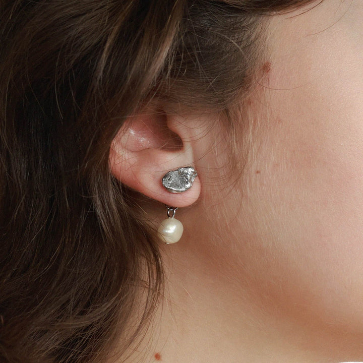 Femme portant une Boucle d'oreilles argentée en étain avec perle suspendue par Anne-Marie Chagnon