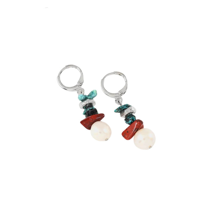 Boucles d'oreilles turquoises et brunes avec perle suspendue par Anne-Marie Chagnon déposées sur une surface