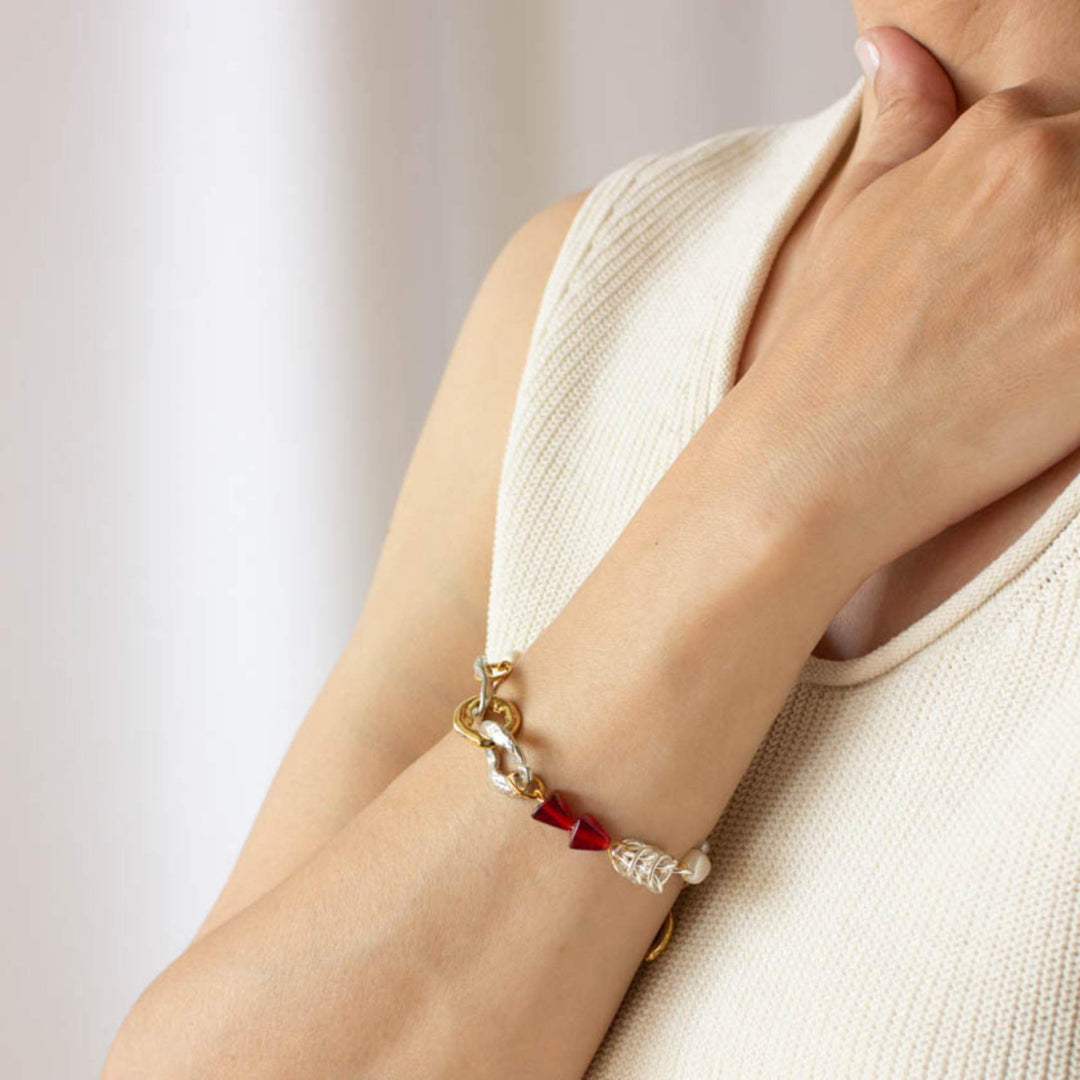 Femme portant un Bracelet Anne-Marie Chagnon immey perles, billes rouges et anneaux argentés et dorés
