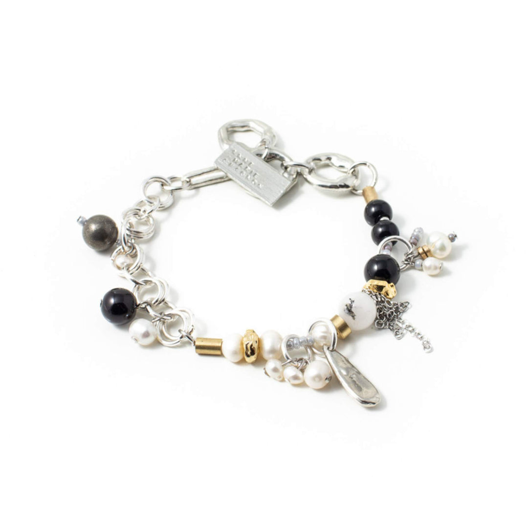 Bracelet Anne-Marie Chagnon Olean argenté avec perles blanches et noires, billes dorées et breloques en étain