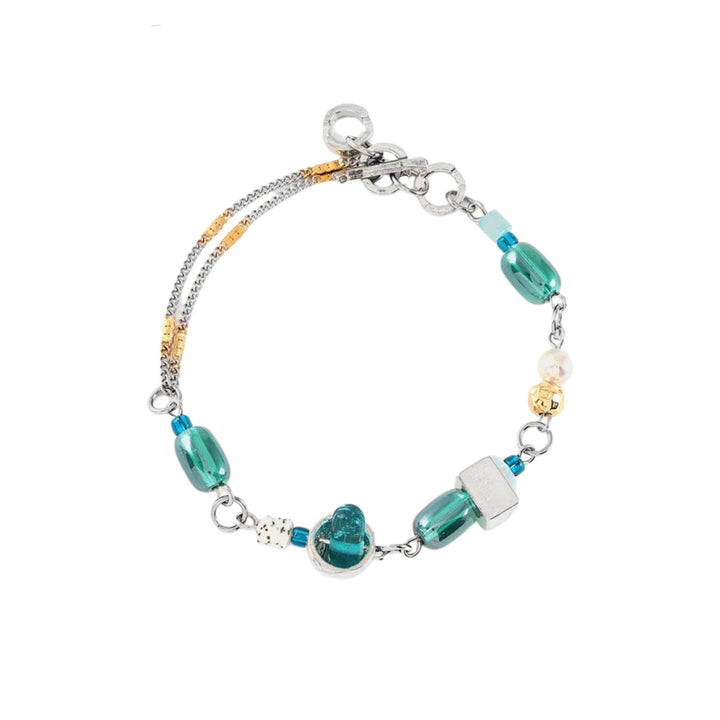 Bracelet avec billes de verre turquoises et perles avec pièces en étain brut et dorées par Anne-marie Chagnon