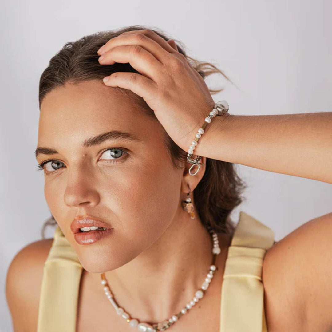 Femme portant des bijoux assortis en étain et plaqués or avec perles par Anne -Marie Chagnon