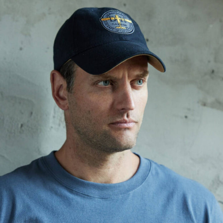 Homme portant une Casquette bleue marine De Havilland avec logo par Red Canoe