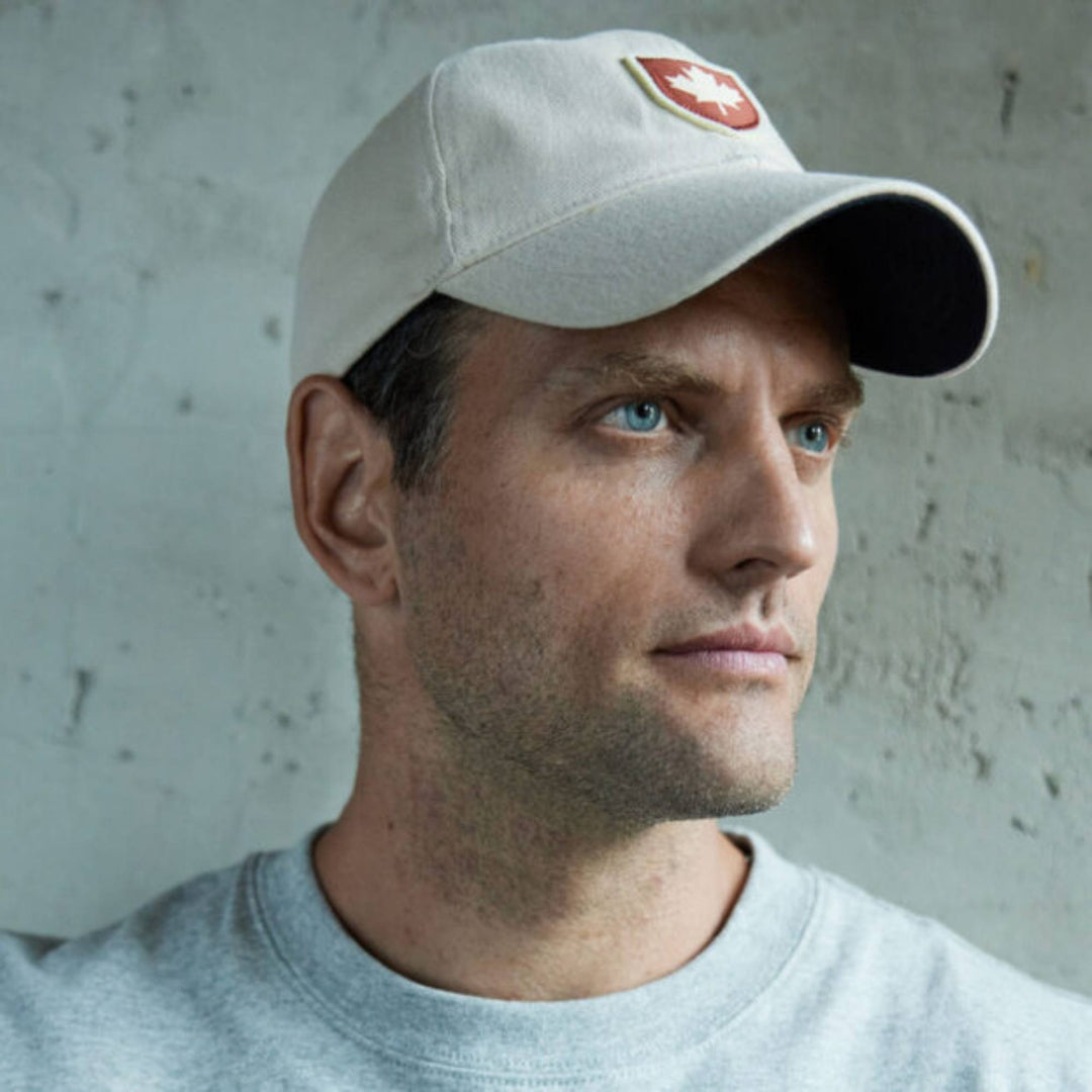 Homme portant une Casquette blanche avec feuille d'érable rouge canada shield par Red Canoe