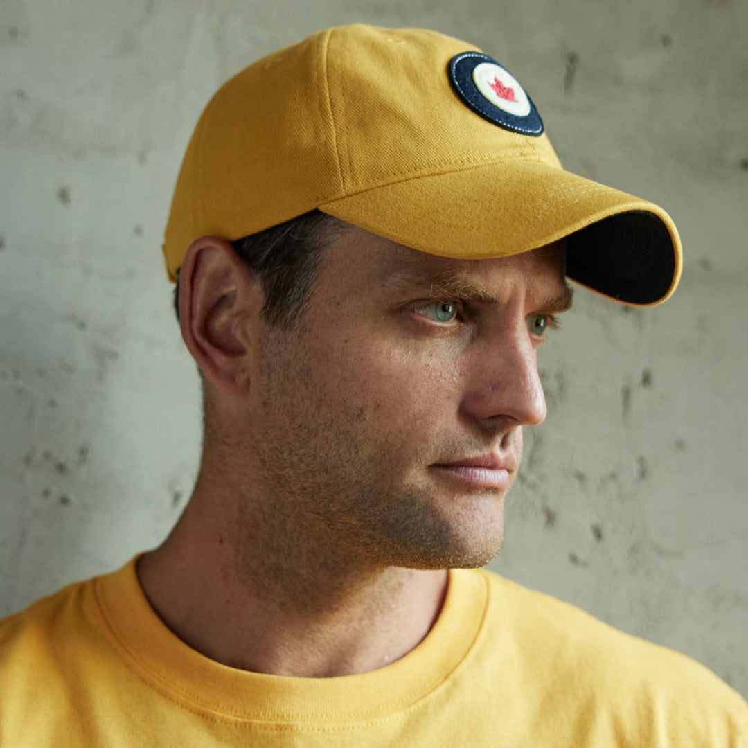 Homme portant une Casquette RCAF jaune avec logo par Red Canoe vu de côté