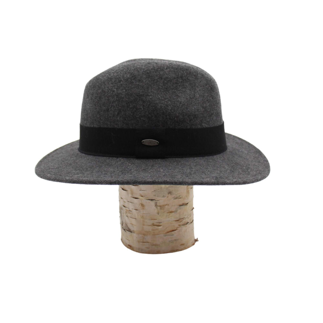 Chapeau fedora Fearn en laine gris avec un ruban noir déposé sur une bûche vu de côté