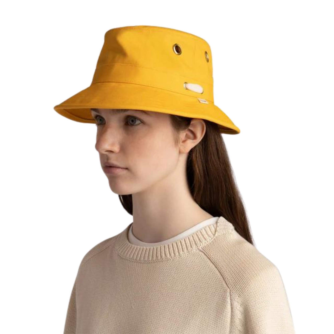 Femme portant un Chapeau iconique T1 jaune par Tilley vue de 3/4