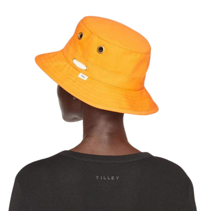 Femme portant un Chapeau Iconique T1 orange par Tilley vue de derrière