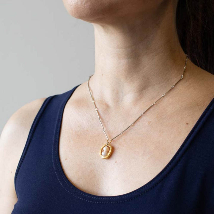 Femme portant un Collier Cadélia argenté et or avec perle par Anne-Marie Chagnon 