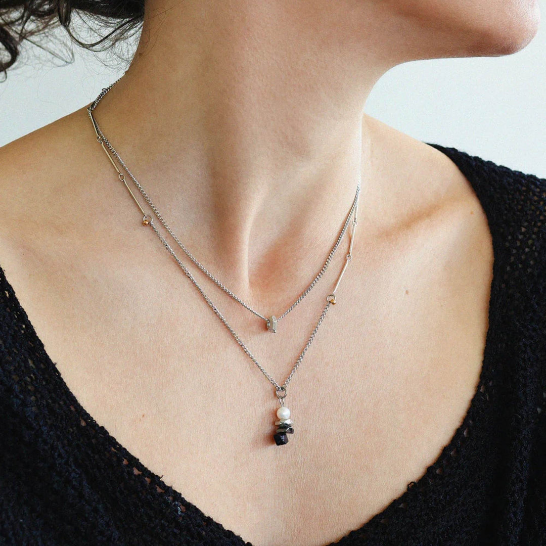 Femme portant un Collier Caelus avec pendentif noir et chaîne argentée par Anne-Marie Chagnon