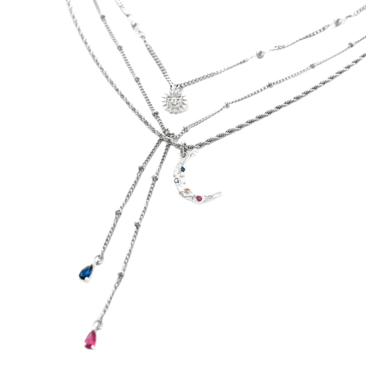 Collier à trois chaînes argentées avec pendentifs de lune, soleil et pierres bleues et rose par welldun en angle