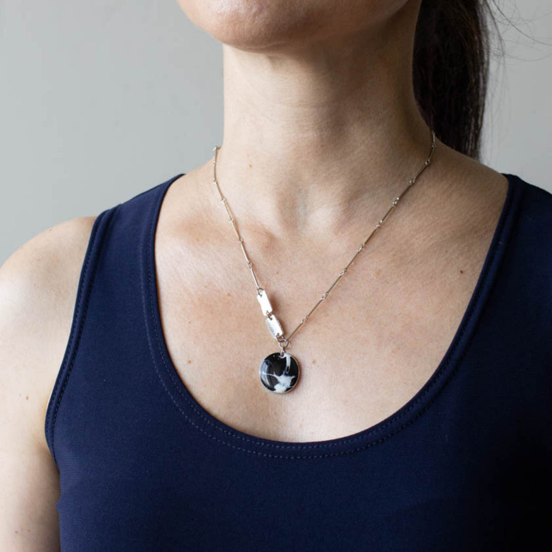 Femme portant un Collier Électra ombre avec pendentif noir et blanc par Anne-Marie Chagnon