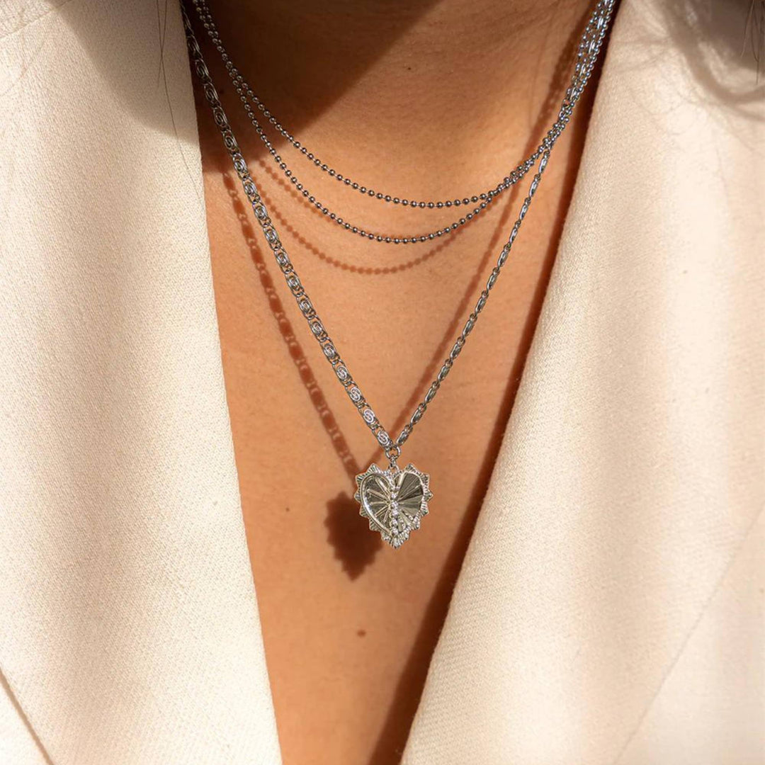 Collier à 3 chaînes argenté avec pendentif en coeur par welldunn dans un cou de femme