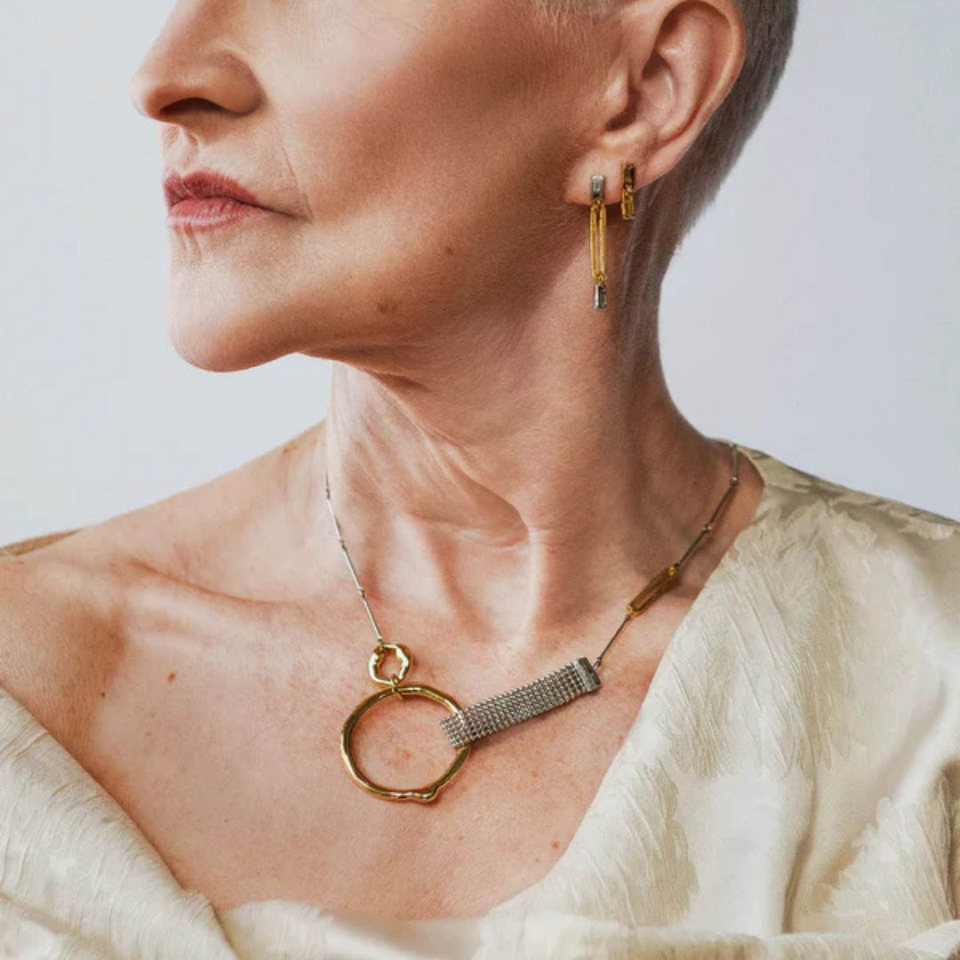 Femme portant un Collier en étain et plaqué or avec anneau doré Kauri par Anne-Marie Chagnon
