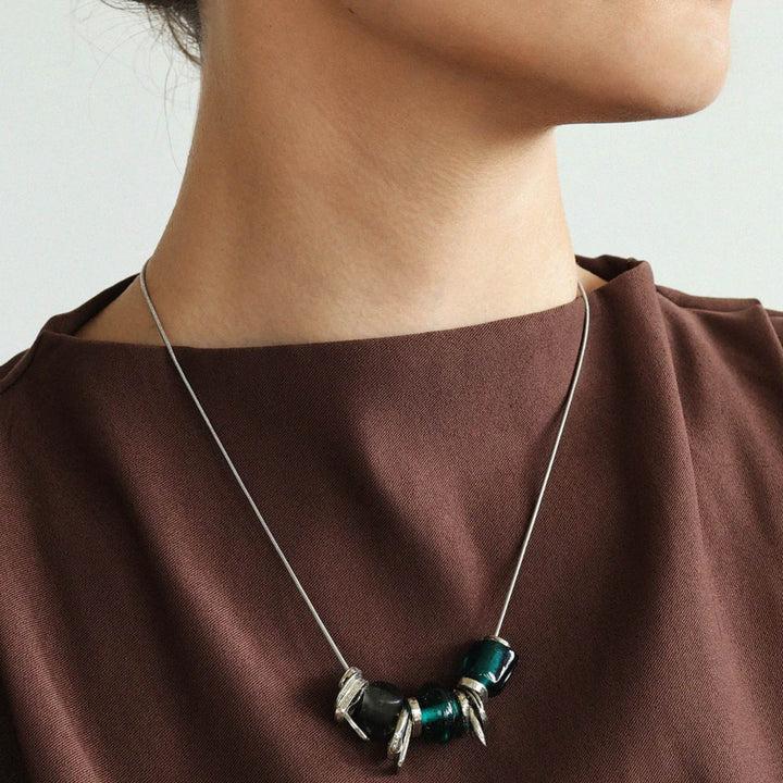 Femme portant un Collier Leona avec billes de verre bleues par Anne-Marie Chagnon