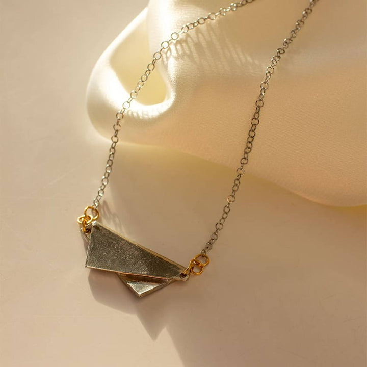 Collier message argent et or avec morceau d'étain plié par Anne-marie Chagnon au soleil