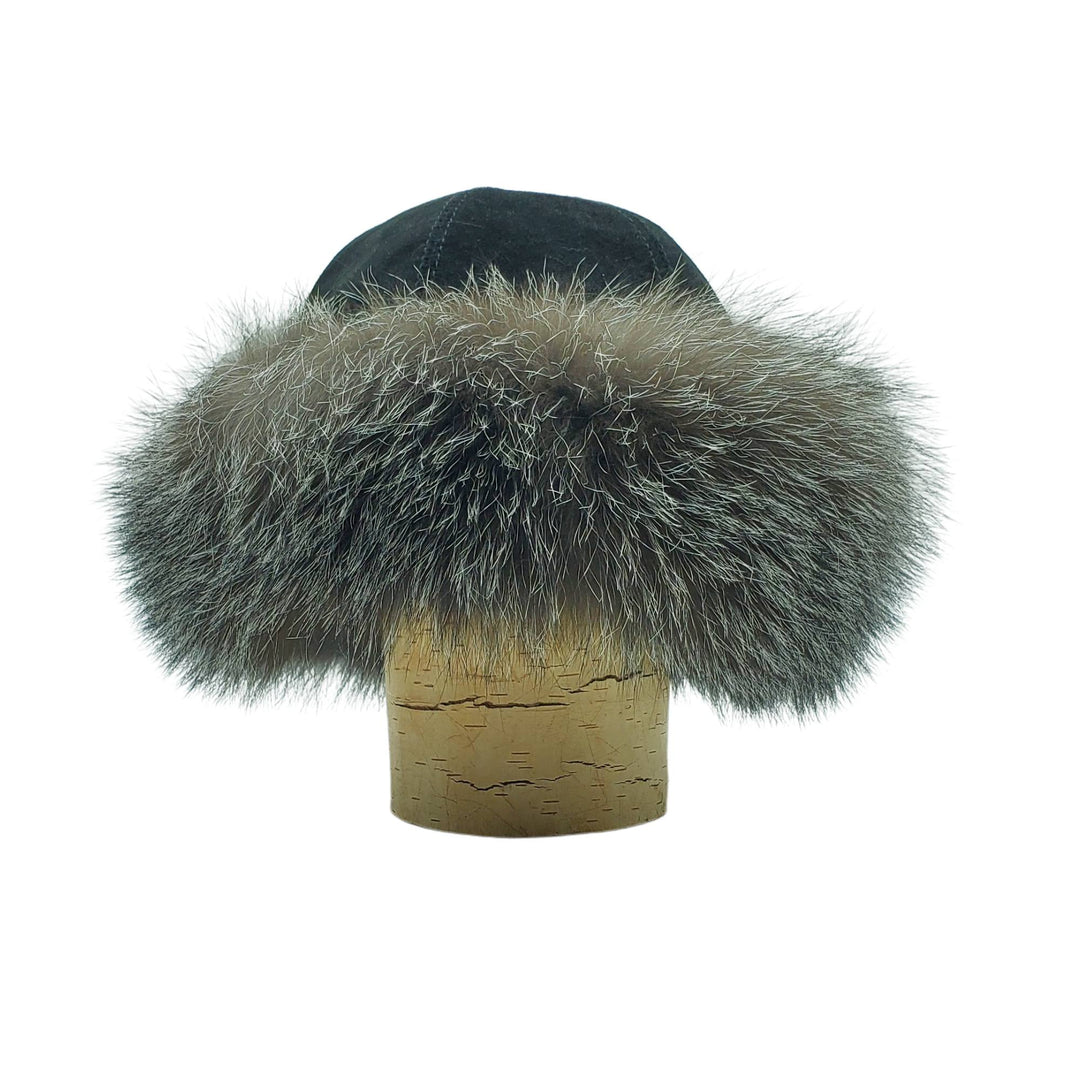 Chapeau style cloche en fourrure de renard gris avec dessus en suède noir par Fourrures Audet vu de devant sur une bûche