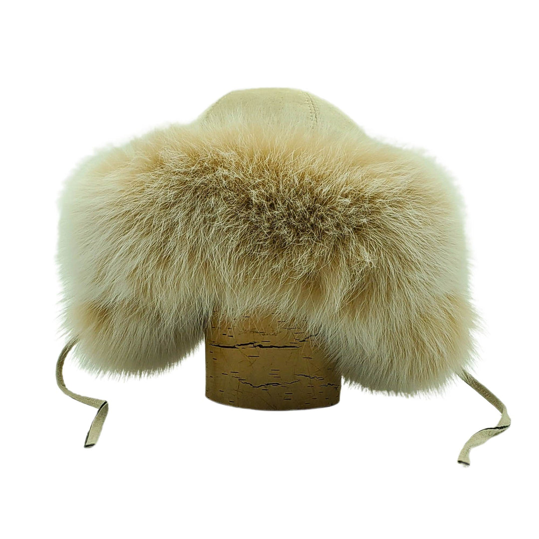 Chapeau style cloche en fourrure de renard beige avec oreilles par Fourrures audet sur une bûche vu de devant