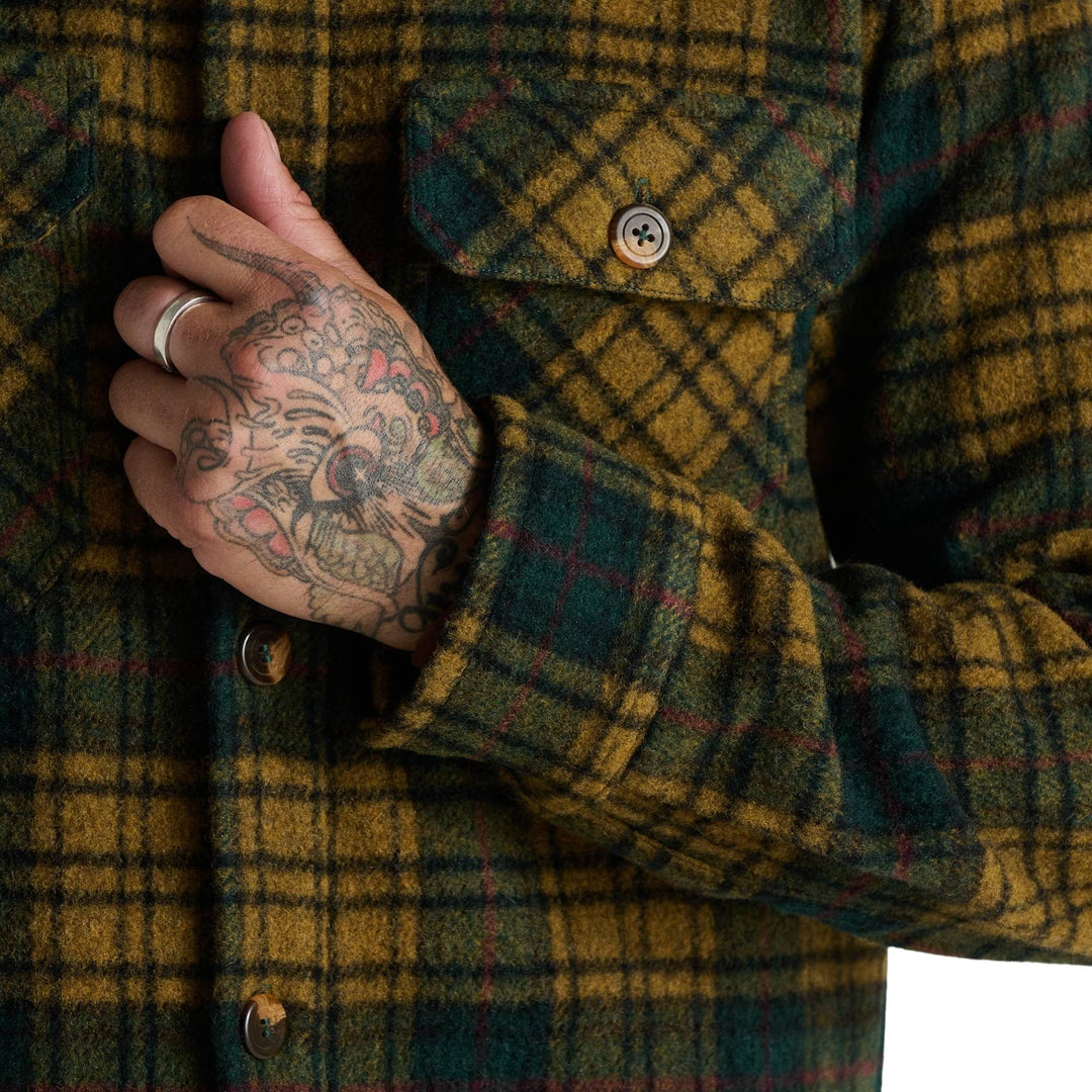 Homme portant un Manteau de laine verte et jaune par Anian vu de proche