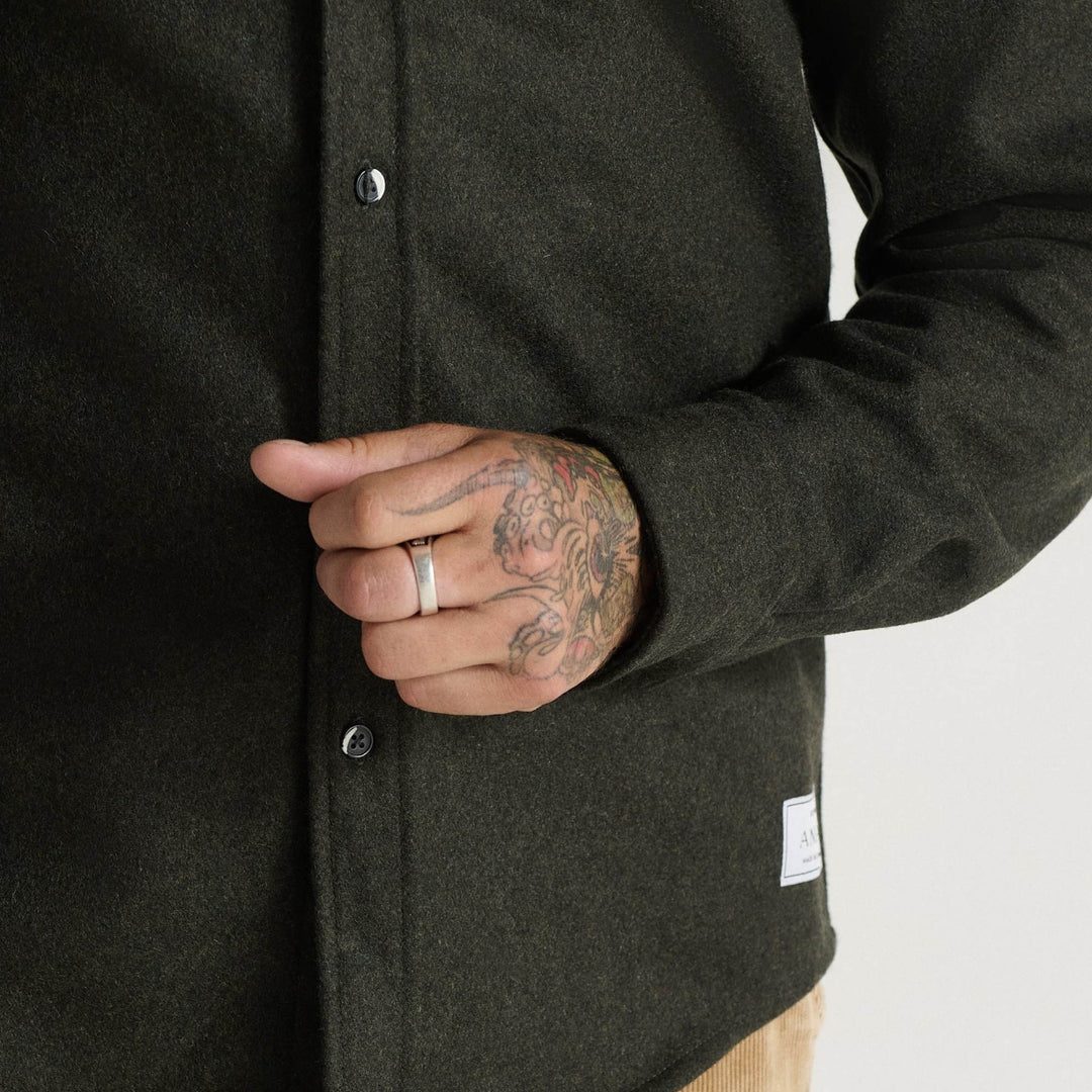 Homme portant un Manteau en laine molton vert par Anian avec vue rapprochée