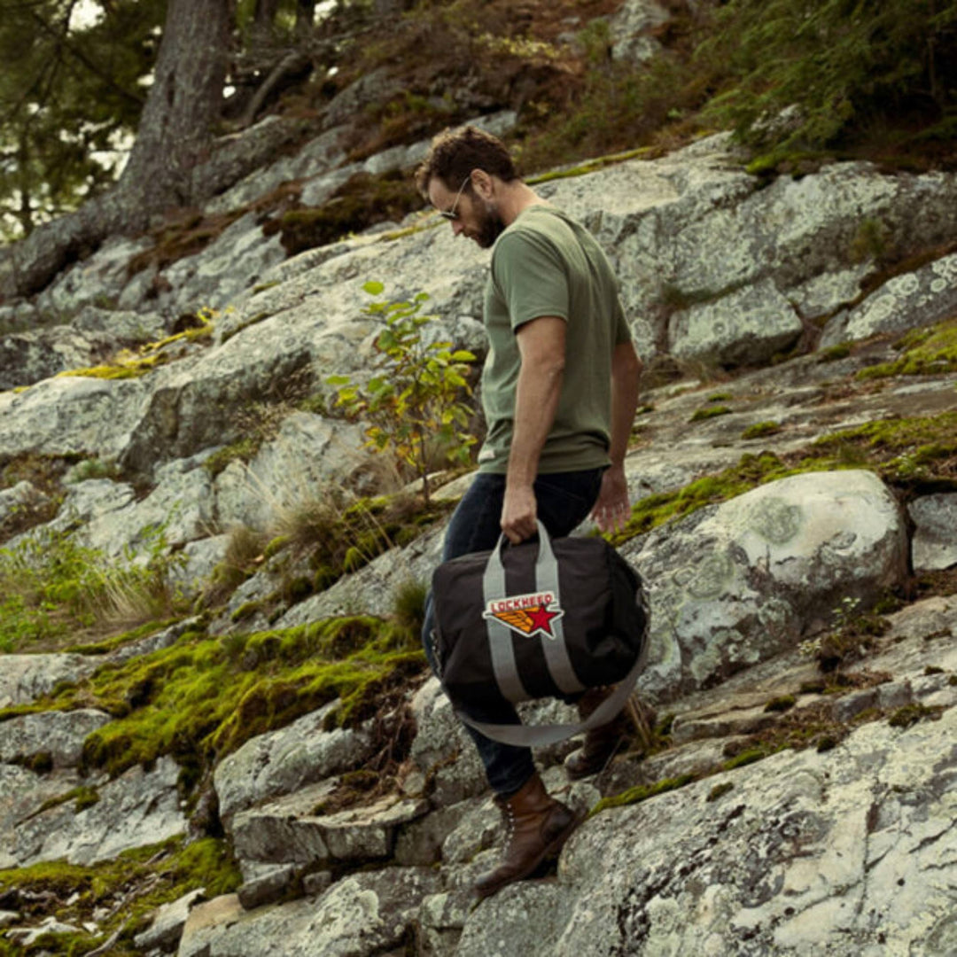 Homme dehors traînant un sac Lockeed par Red Canoe