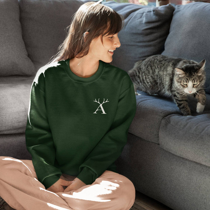 Femme assise devant un sofa avec un chat portant un Coton ouaté vert avec le logo d'Artisans canada