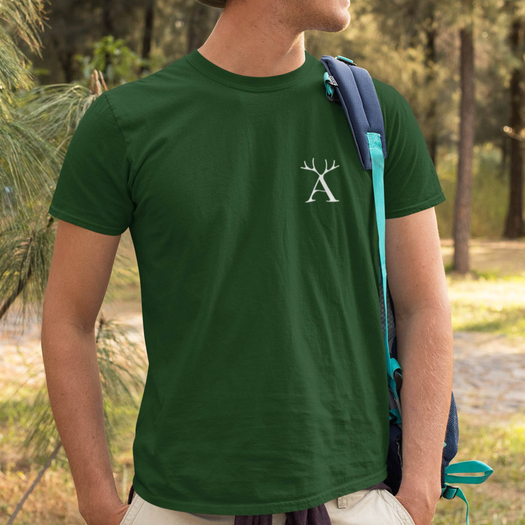 Homme portant un t-shirt vert Artisans canada dans la forêt