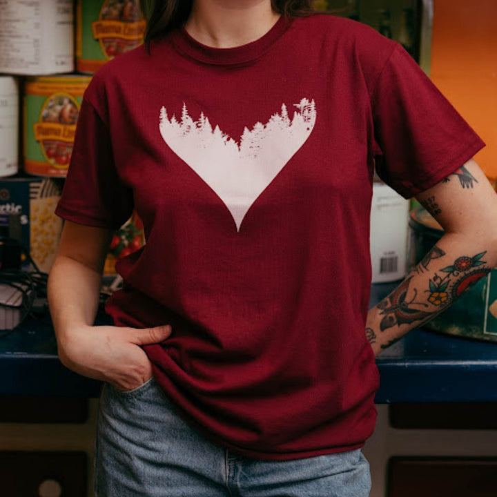 Femme portant un t-shirt bordeaux avec un coeur et une forêt comme motif par KM54