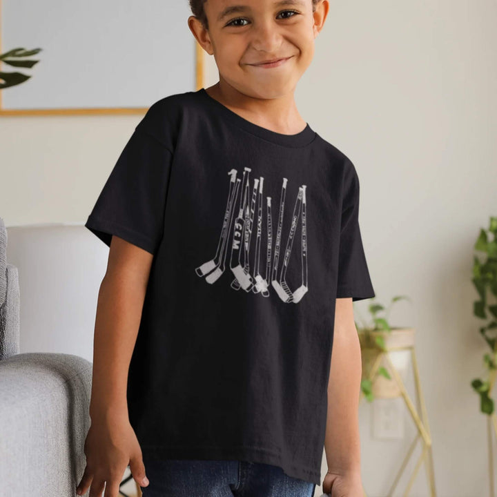 Enfant portant un t-shirt noir avec des bâtons de hockey par KM54