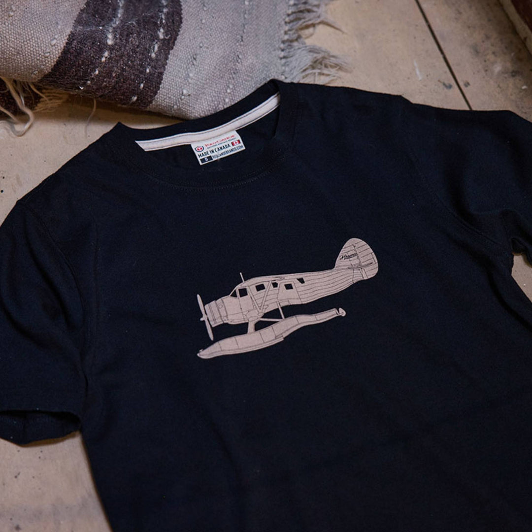 T-shirt Norseman noir par Red Canoe déposé sur un plancher de bois