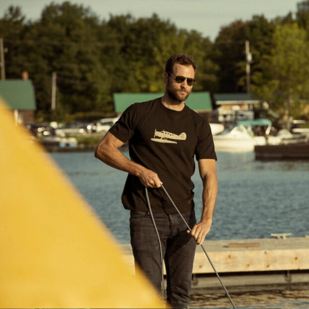 Homme portant un Tshirt Norseman noir par Red Canoe sur un quaie