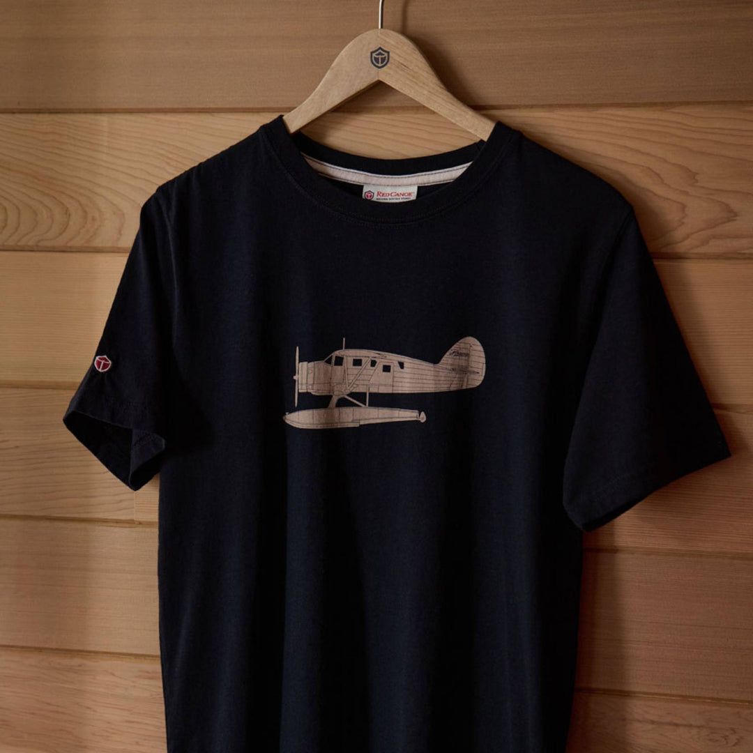 T-shirt Norseman noir par Red Canoe accroché sur un cintre devant un mur en bois