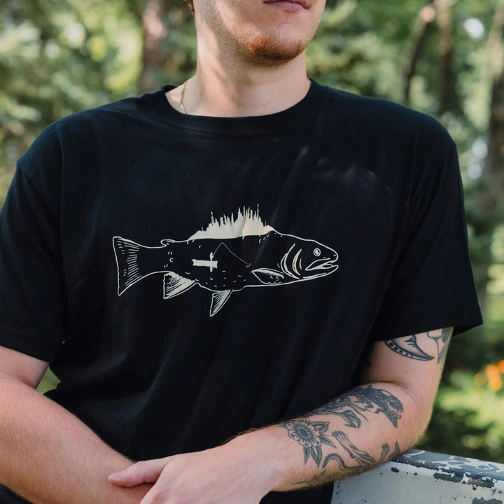 Homme dehors portant un t-shirt noir avec un poisson et un pêcheur dans un canoe par KM54