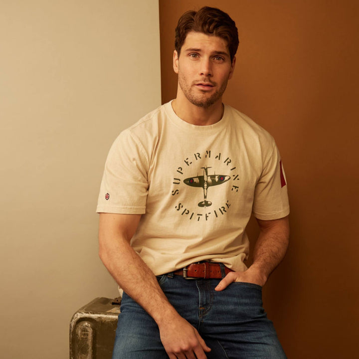 Homme portant un T-shirt super marine spitfire blanc par Red Canoe et un jeans bleu