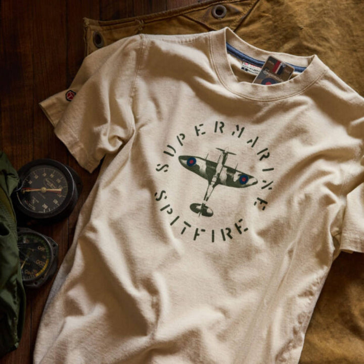T-shirt super marine spitfire blanc déposé sur le sol près de boussoles par Red Canoe