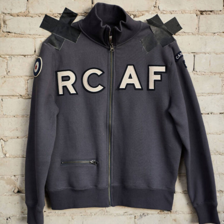 Veste à fermeture éclair RCAF bleue pour homme par Red Canoe accrochée au mur
