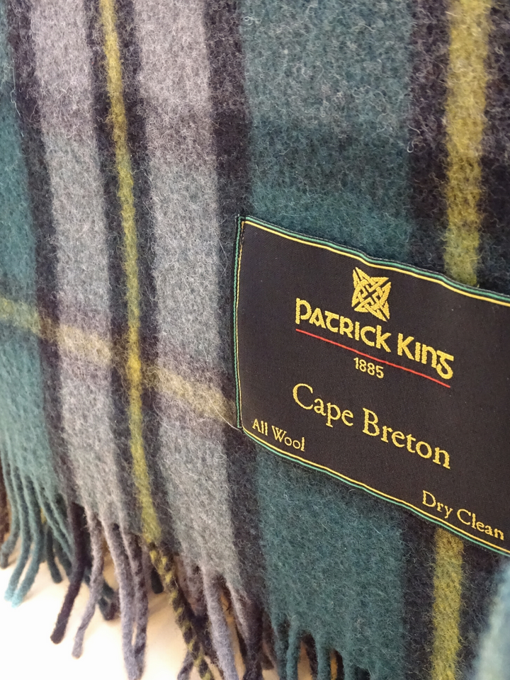Détails étiquette Patrick King d'une lourde couverture tartan verte et grise avec fines lignes jaunes