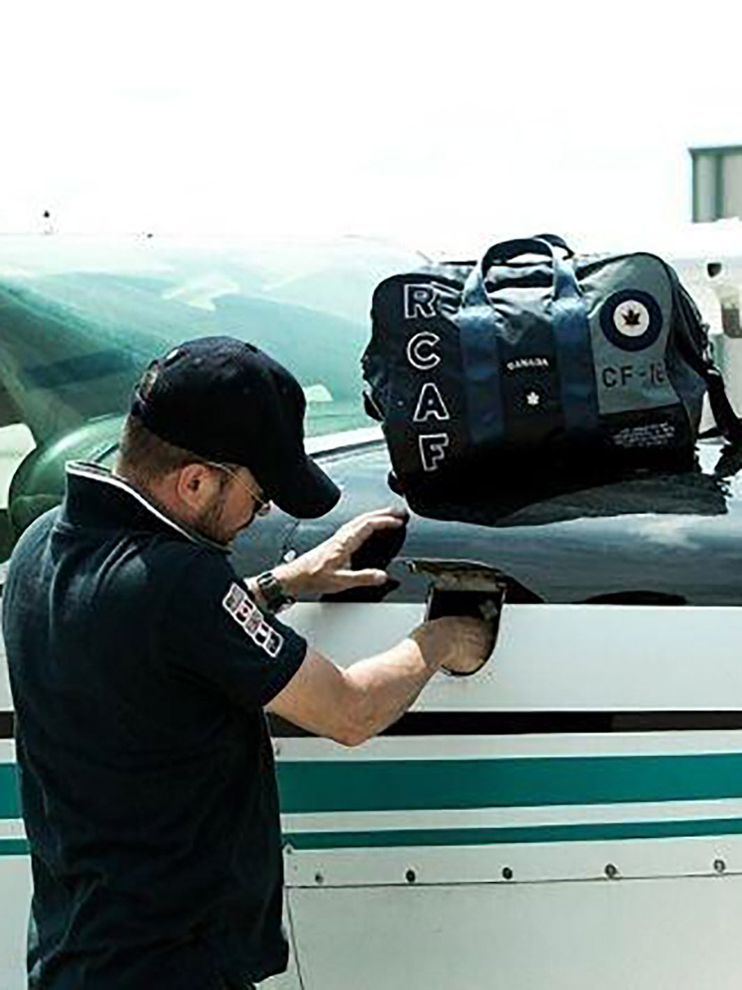 Homme s'occupant de son avion avec un sac RCAF marine