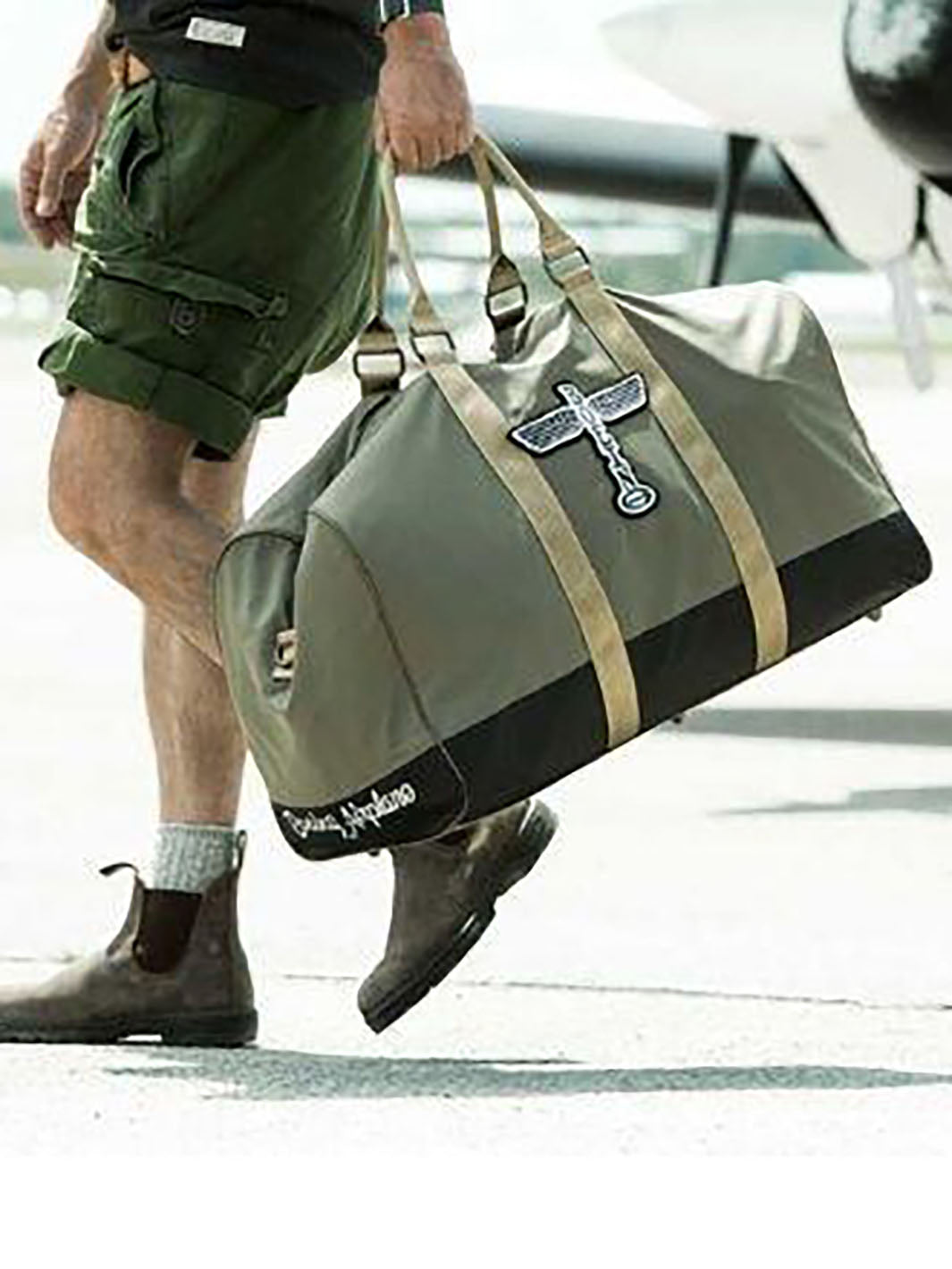 Homme transportant un sac duffle bag Boeing Totel kaki avec poignées