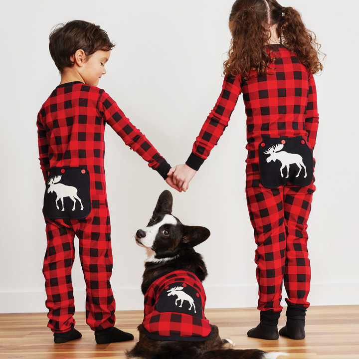 Enfants de dos avec un chien portant des combinaisons assorties tartans rouges et noirs avec motif d'orignal blanc