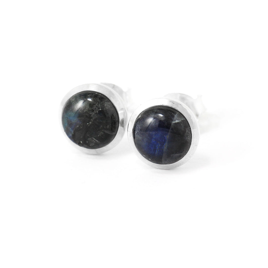 boucle d'oreille studs avec rebord en argent. Pierre ronde de couleur bleu profond. 