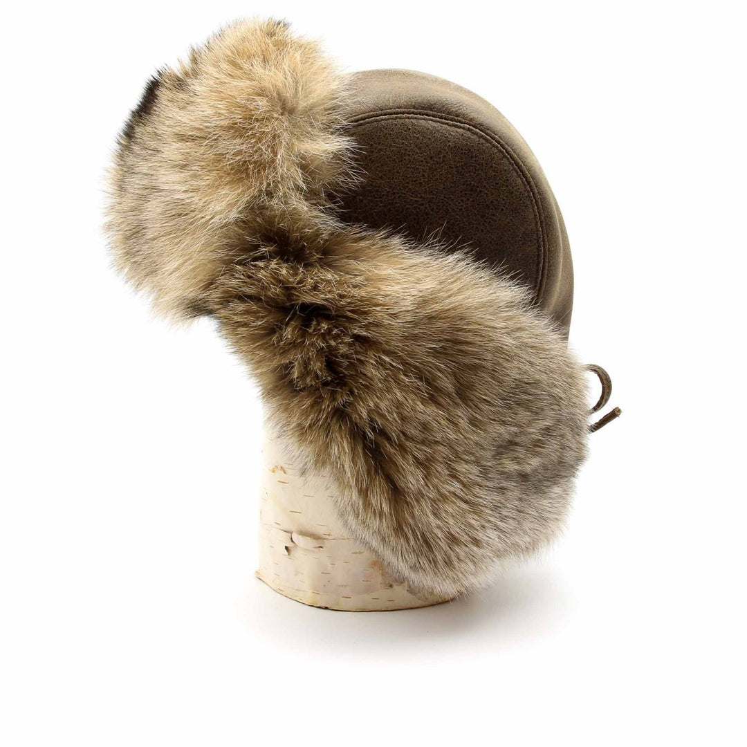 chapeau de fourrure style chapka vue de côté. Le cuir est brun et la fourrure de lynx beige pâle.