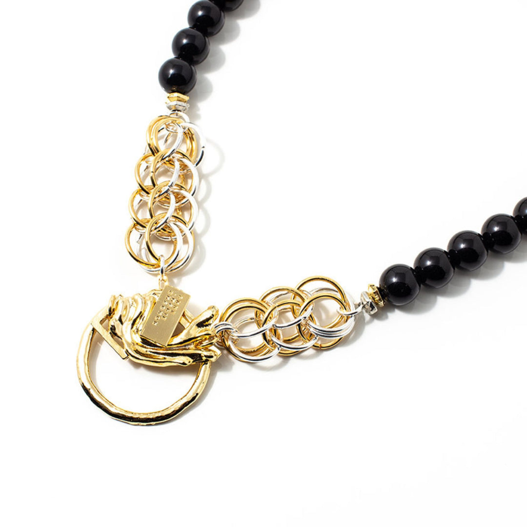 Collier Anne-marie Chagnonavec grosses perles noires et anneaux dorés et argentés avec pendentif doré