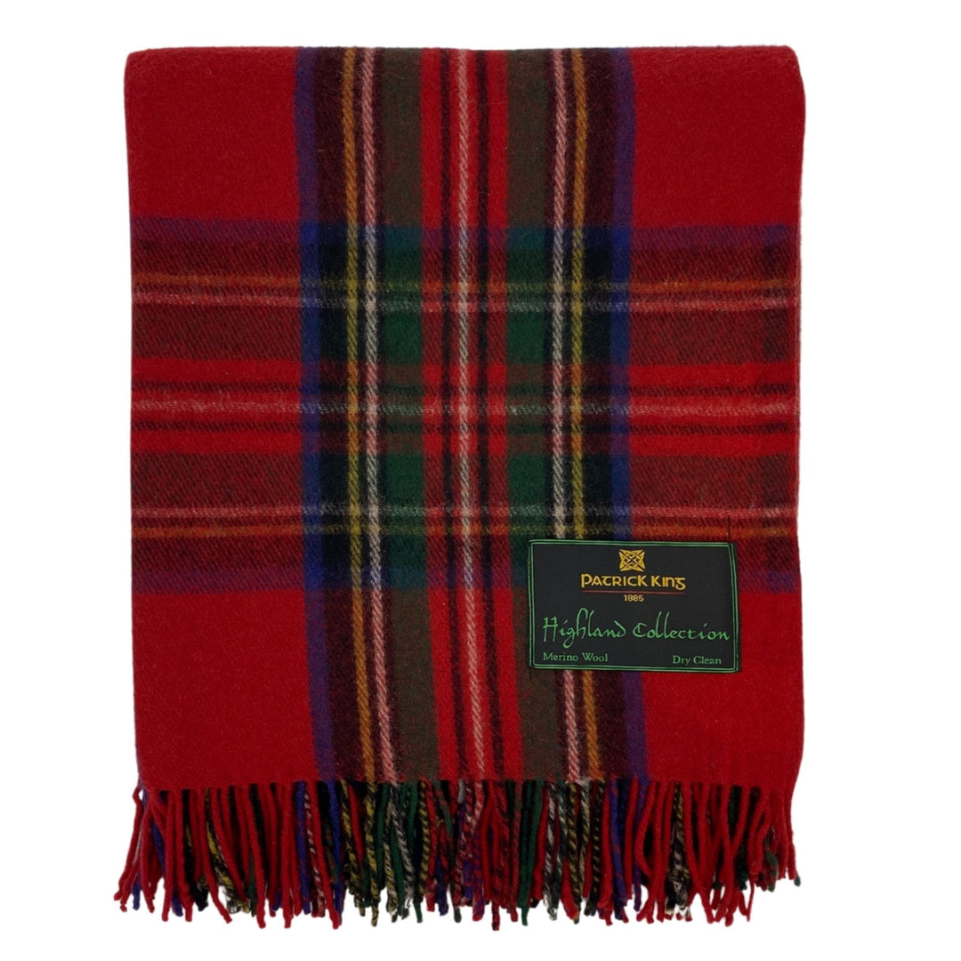Lourde couverture tartan Highland Collection rouge avec lignes vertes,blanches, noires et bleues pliée avec franche dans le bas et une étiquette Patrick King dans le bas droit