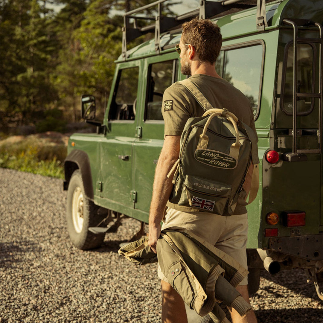 Homme de dos portant un Sac à dos Land Rover kaki par Red Canoe vu de derrière