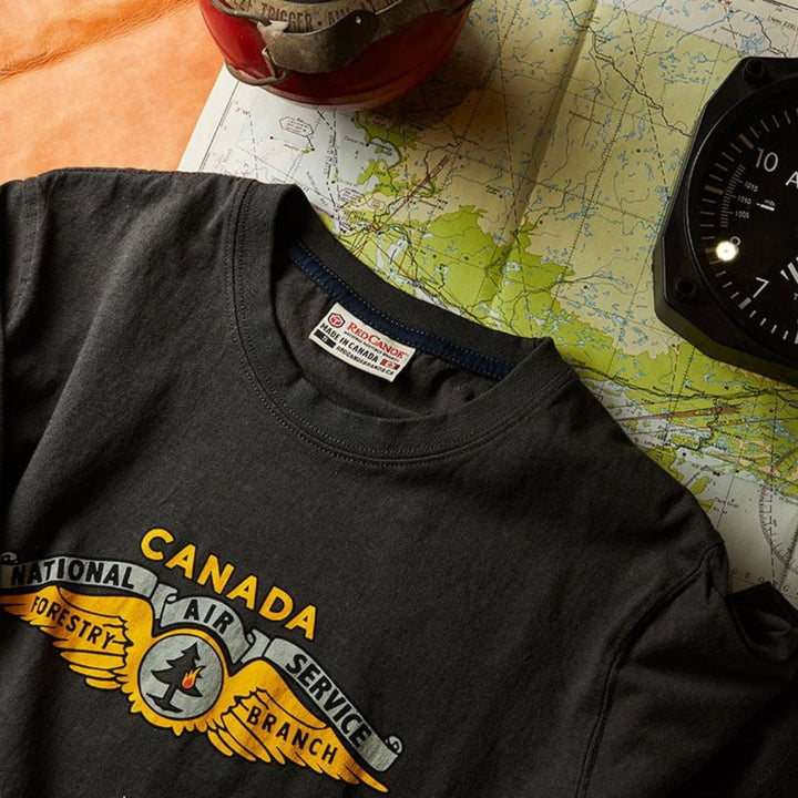 t-shirt air service posé sur une table avec une carte géographique et une boussole